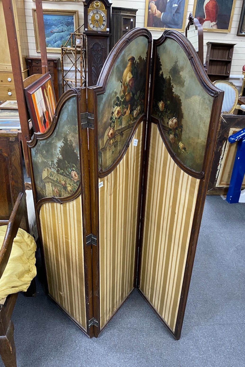 An early 20th century oak three fold screen, painted oil on canvas panels and stretched silk, height 154cm